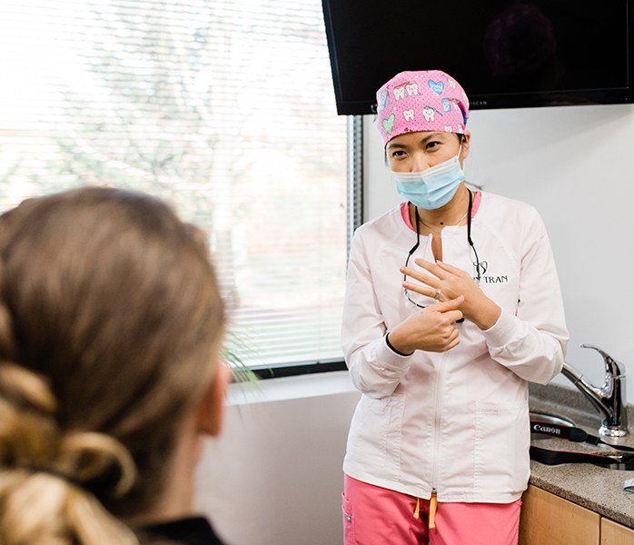 Doctor Tran talking to dental patient