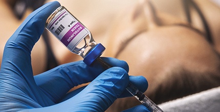 Gloved hand preparing BOTOX injection