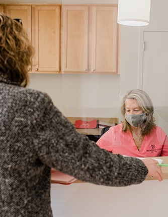 Dental patient talking to receptionist at front desk