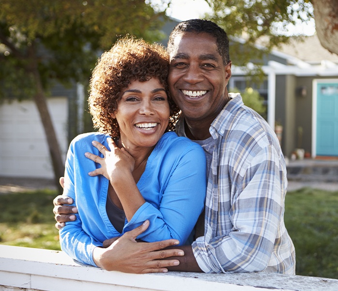 Man and woman sharing healthy smiles after dental checkups and teeth cleanings