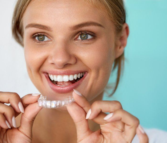 Woman placing an Invisalign clear braces tray