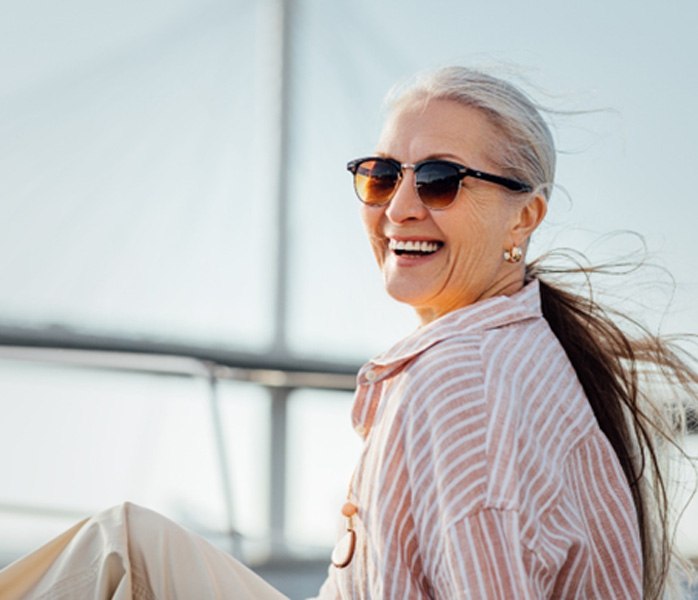 Senior woman with sunglasses sitting on a boat