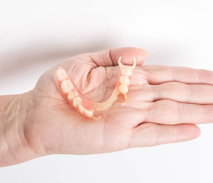 Hand holding a partial denture