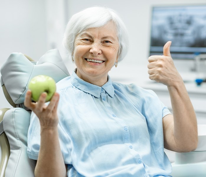 Woman with dentures holding an apple