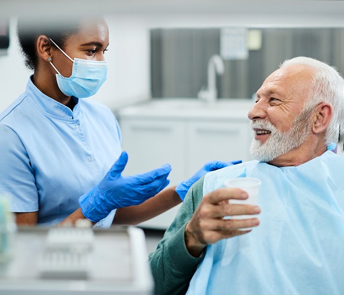 mature dentures candidate in Millersville talking to dentist 