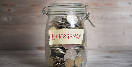 Jar of coins labeled “emergency” for the cost of dental emergencies in Millersville