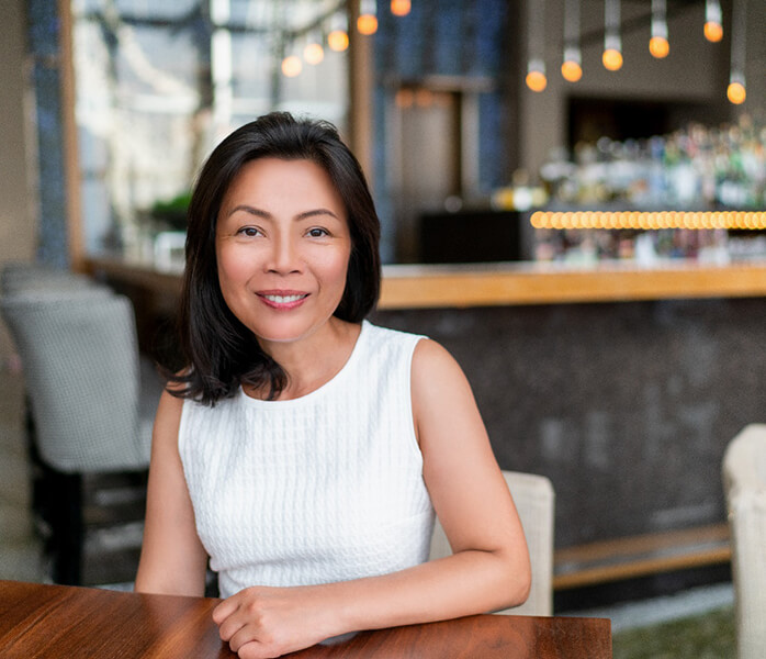 Woman in café smiling after toothache treatment