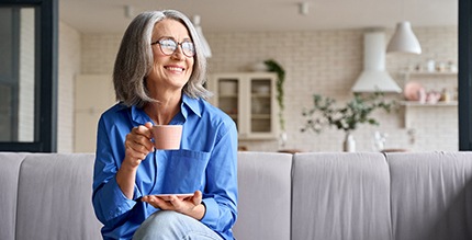 a person relaxing on their couch with a cup of coffee