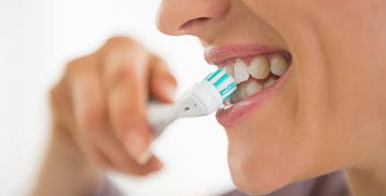 a person brushing and caring for their dental implants