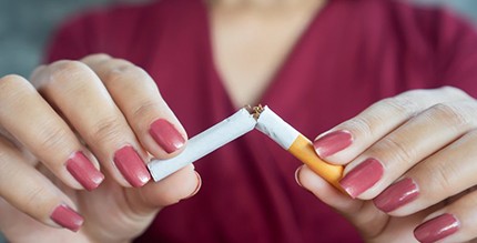 a woman breaking a cigarette in half