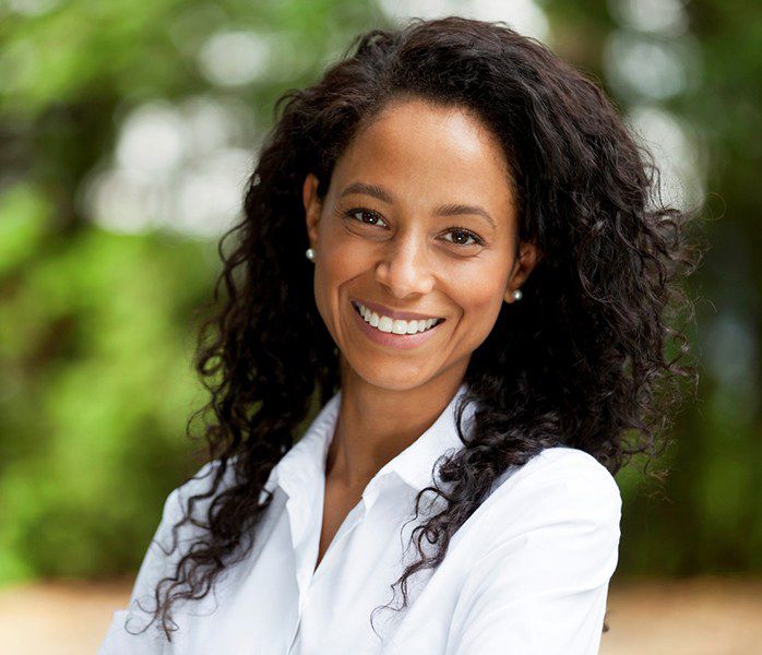 Younger woman smiling after learning dental implant post-op instructions in Millersville