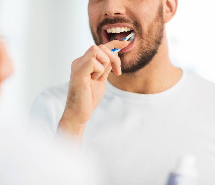 Man brushing his dental implants in Millersville