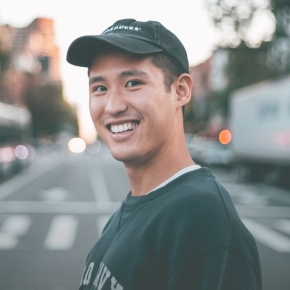 Young man smiling on city sidewalk