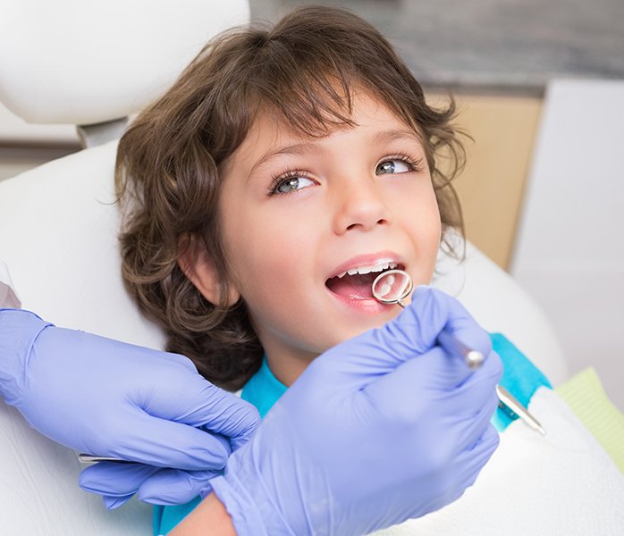 Child receiving exam during children's dentistry visit