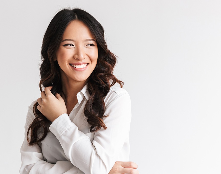 Woman showing off smile with porcelain veneers