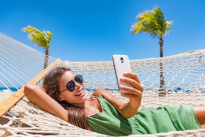 person taking picture while on a hammock