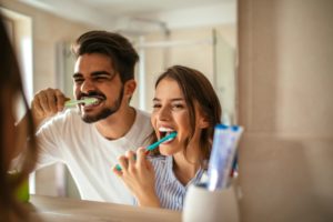 Man and woman brushing their teeth