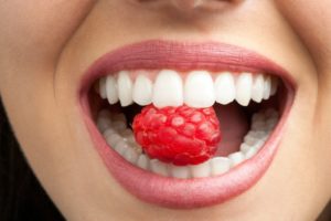 a woman biting a raspberry