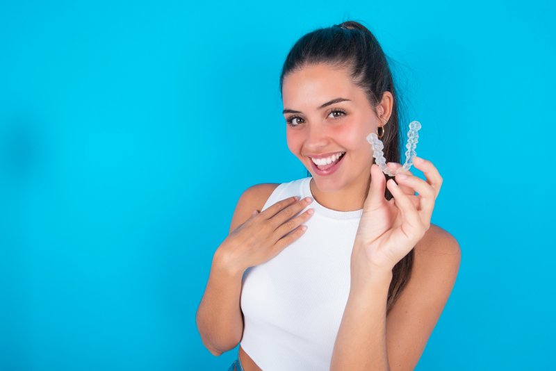 young woman holding her invisalign aligner 
