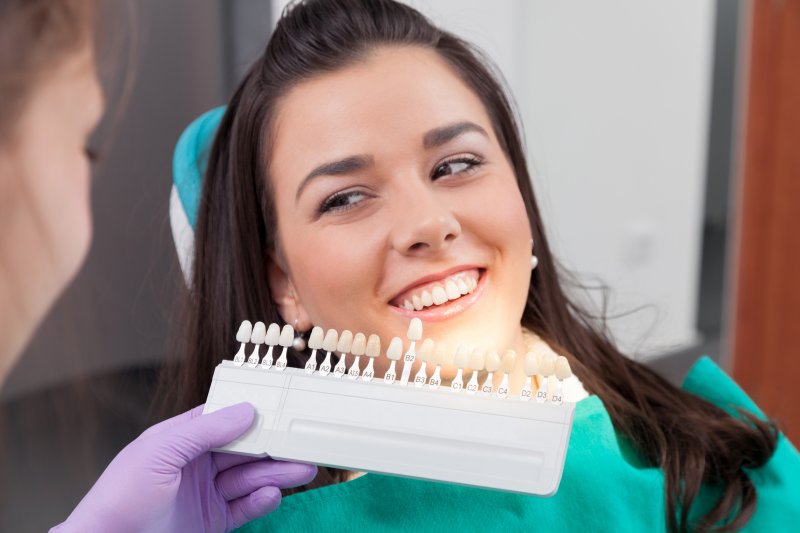 A woman selecting her preferred tooth color for cosmetic dentistry