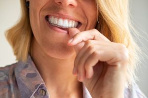 Woman pressing Invisalign over her teeth