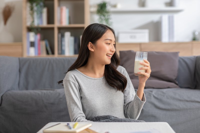 A smiling woman holding a glass of milk