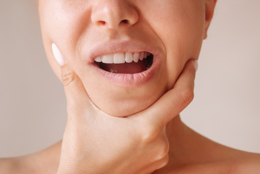 Woman holding jaw in pain