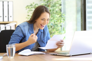 Patient celebrating at her desk because she can afford cosmetic dentistry